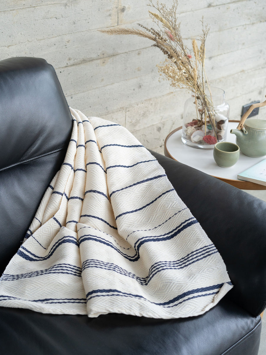 Releve Fashion WVN Living Handwoven Navy Cream Drift Throw Blanket and Towel Sustainable Luxury Fashion Conscious Clothing and Lifestyle Accessories Ethical Designer Brand Artisanal Handcrafted Beachwear Home Accessories Purchase with Purpose Shop for Good
